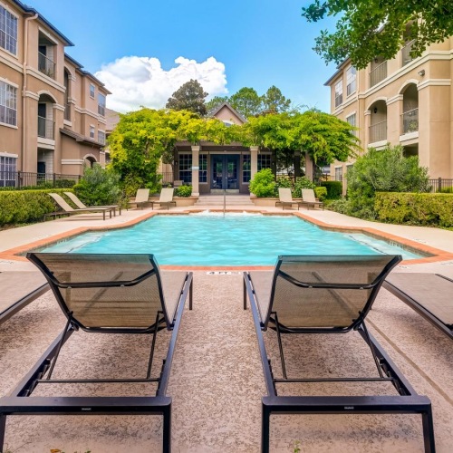 a swimming pool with lounge chairs